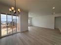 Open-concept living room with sliding glass doors to the deck and hardwood floors at 6966 E 126Th Pl, Thornton, CO 80602