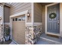 A detailed view of the front entrance, stone accents, and a welcoming wreath at 7258 Oasis Dr, Castle Rock, CO 80108