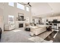 Bright living room with soaring ceilings, fireplace, and open-concept layout to kitchen at 7258 Oasis Dr, Castle Rock, CO 80108