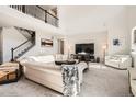 Bright living room with soaring ceilings, fireplace, and staircase to the second floor at 7258 Oasis Dr, Castle Rock, CO 80108