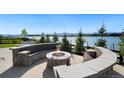 Stone fire pit with seating area and lake view at 2599 Heron Lakes Pkwy, Berthoud, CO 80513