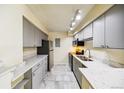Charming kitchen with updated stainless steel appliances, grey cabinets, and marble countertops at 1020 15Th St # 13K, Denver, CO 80202