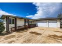 Ranch-style home featuring a ramp leading to the front door and an oversized garage with a large concrete driveway at 16710 Vincent Ave, Monument, CO 80132