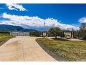 Exterior view of a home featuring an oversized garage with a long driveway, an American flag, and mountain views at 16710 Vincent Ave, Monument, CO 80132