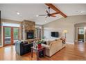 Bright living room with a stone fireplace, hardwood floors and a wooden beam ceiling at 1055 Divide View Dr, Golden, CO 80403