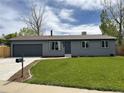 Charming single-story home with a well-maintained lawn, gray exterior, and an attached garage with a new driveway at 7054 Welch Ct, Arvada, CO 80004
