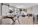 Open-concept living area featuring modern decor, a dining area, and a sunlit living space with luxury vinyl flooring at 7054 Welch Ct, Arvada, CO 80004