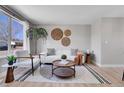 Bright living room with large window, modern furniture, stylish rug, and decorative wall art that enhances this living space at 7054 Welch Ct, Arvada, CO 80004