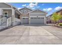 View of the driveway of a home with a two-car garage, showing its ample space, and partial views of the front yard at 8772 S Sicily Ct, Aurora, CO 80016