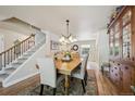 Bright dining room boasts hardwood floors, chandelier, and staircase access for elegant meals and gatherings at 5225 S Everett Ct, Littleton, CO 80123