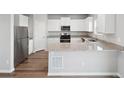 Modern kitchen with stainless steel appliances, granite countertops, stylish cabinets and hardwood floors at 2174 Alyssa St, Fort Lupton, CO 80621