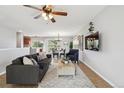 Open-concept living area with modern decor, ceiling fan, and seamless flow to dining space at 4231 W Ponds Cir, Littleton, CO 80123