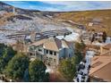 Aerial view of home surrounded by mature trees and mountain backdrop at 10488 Bluffmont Dr, Lone Tree, CO 80124
