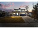 Inviting two-story home featuring stylish architectural details, warm exterior lighting, and a lush front lawn at 3041 S Bellaire S St, Denver, CO 80222