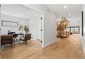 Open hallway featuring wood floors, a modern staircase, and a view into the home office at 3041 S Bellaire S St, Denver, CO 80222