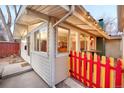 Back exterior showcasing an enclosed patio area, string lights, and a colorful fence, perfect for outdoor enjoyment at 2370 S Meade St, Denver, CO 80219