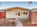 Front exterior view of a cozy home, showcasing the entrance and a brick wall at 2370 S Meade St, Denver, CO 80219