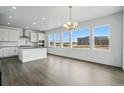 Modern kitchen featuring white cabinets, stainless steel appliances, a large island, and ample natural light at 16890 Black Rose Pl, Parker, CO 80134