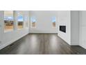 Bright living room features high ceilings, large windows, luxury vinyl plank flooring, and a modern fireplace at 16890 Black Rose Pl, Parker, CO 80134