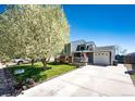 Inviting home with a spacious driveway, well-kept lawn, and blossoming trees at 862 Centennial Way, Bennett, CO 80102