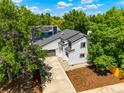 Aerial view of a well-manicured home with lush trees, a private driveway, and manicured landscaping at 202 Hoover Ave, Louisville, CO 80027