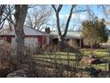 Scenic shot of a ranch-style home with mature trees, a well-manicured lawn and tasteful design at 7250 County Road 5, Erie, CO 80516
