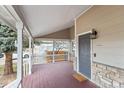 Inviting covered front porch featuring a wood-plank floor and stone accents on the home's facade at 13124 Tejon St, Westminster, CO 80234