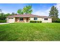 Charming single story home with a well manicured lawn, a front porch, and an attached one car garage at 2445 Vance St, Lakewood, CO 80214