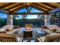 Covered patio boasts comfortable seating around a cozy gas fire pit with scenic views at 11848 Begole Cir, Golden, CO 80403