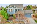 Attractive two-story home showcasing blue siding and stone accents complemented by a well-kept lawn at 15767 E 109Th Ave, Commerce City, CO 80022