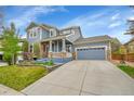 Beautiful two-story home with blue siding and stone accents, a well-maintained lawn, and a spacious driveway at 15767 E 109Th Ave, Commerce City, CO 80022