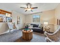 Cozy Gathering room with plush seating, modern ceiling fan, and an adjacent view to the kitchen at 12432 Bellaire St, Thornton, CO 80241