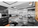 Modern kitchen featuring stainless steel appliances, black granite countertops, and sleek white cabinetry at 1551 Larimer St # 1106, Denver, CO 80202