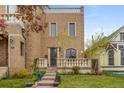 Beautiful brick home with a well-manicured lawn, front porch and budding trees at 2330 N Emerson St, Denver, CO 80205