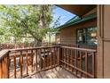 Wooden porch featuring railings and stairs, set amongst mature trees and nature at 838 Lakeshore Dr, Boulder, CO 80302