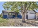 Charming single-story home featuring a well-maintained yard, a two-car garage, and a welcoming blue front door at 5222 Xanadu St, Denver, CO 80239