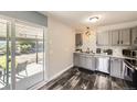 Modern kitchen with stainless steel appliances, gray cabinets, and sliding glass doors leading to the outdoor patio at 5222 Xanadu St, Denver, CO 80239