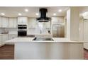 Modern kitchen features white cabinets, stainless steel appliances, and an island with cooktop at 7255 E Quincy Ave # 404, Denver, CO 80237