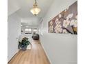 Entry hallway featuring hardwood floors, modern light fixture, and artwork on the wall at 10149 W 55Th Dr # 101, Arvada, CO 80002