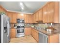 Well-lit kitchen features stainless steel appliances, granite counters, and wood cabinets at 10149 W 55Th Dr # 101, Arvada, CO 80002