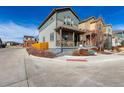 Charming two-story home featuring a covered front porch with seating and landscaped front yard at 12705 Ulster St, Thornton, CO 80602