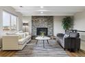 Cozy living room featuring a stone fireplace, plush seating, and ample natural light at 8746 Sunridge Hollow Rd, Parker, CO 80134