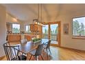 Open dining area with wood floors, access to the deck, and modern lighting for a relaxed atmosphere at 100 Apache Rd, Evergreen, CO 80439