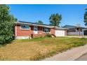 Lovely brick home featuring an attached garage, solar panels, and a cozy front porch in a desirable neighborhood at 8140 Pennsylvania Way, Denver, CO 80229