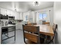 Well-lit kitchen with white cabinets, blue backsplash, and a dining area perfect for Gathering meals at 8140 Pennsylvania Way, Denver, CO 80229