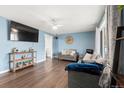 Inviting living room featuring a ceiling fan, hardwood floors, and large windows for ample natural light at 8140 Pennsylvania Way, Denver, CO 80229