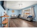 Bright living room with wood floors, large windows, ceiling fan, and neutral paint, creating a cozy space at 8140 Pennsylvania Way, Denver, CO 80229