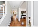 Inviting foyer featuring gleaming hardwood floors, textured wallpaper, and a glimpse into the adjacent living spaces at 995 S Jackson St, Denver, CO 80209