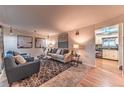 Cozy living room featuring comfortable seating, stylish decor, and an open doorway to the kitchen area at 1583 Skeel St, Brighton, CO 80601