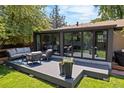 Enjoy outdoor living on this backyard deck with stylish seating and glass-enclosed sunroom at 5525 E Bails Dr, Denver, CO 80222